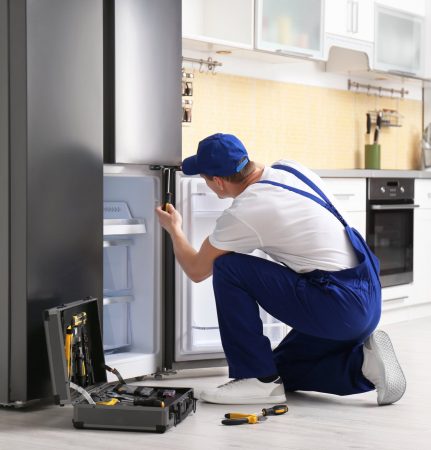 a technician repairing a refrigerator - Top Appliance Repair Camden